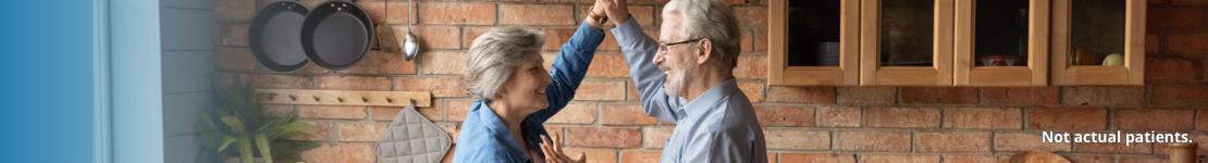 A man and woman dancing in a kitchen.