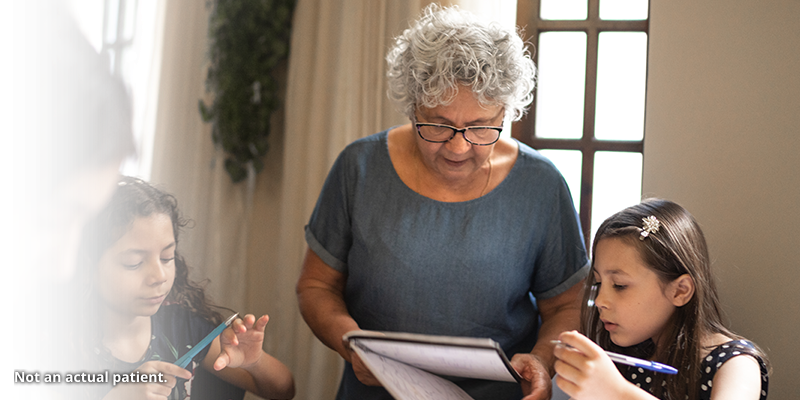 Older woman looking at a notebook with a young girl.